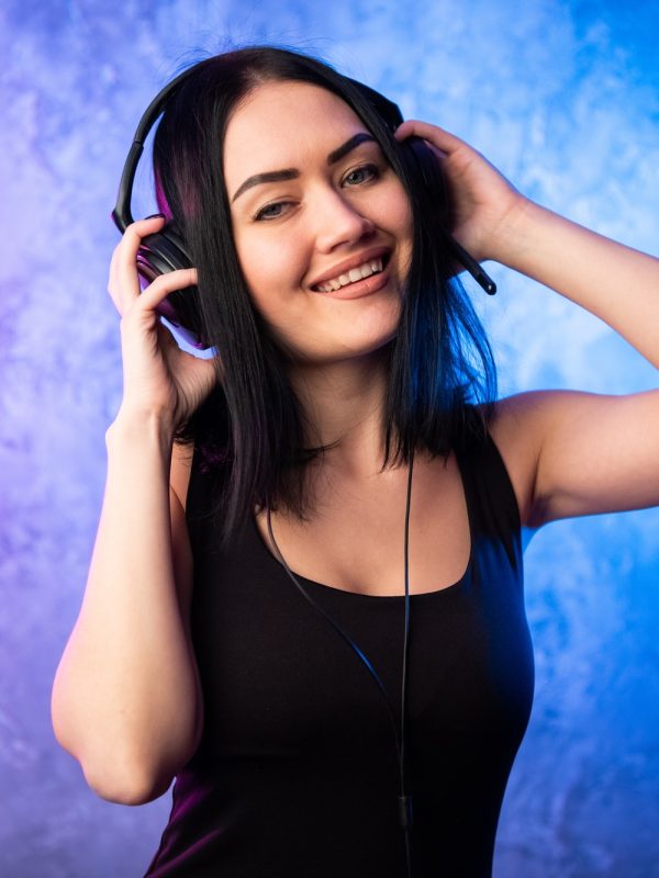 colorful-portrait-in-blue-and-pink-ligth-of-a-young-dj-woman-wearing-headset-and-enjoying-an.jpg